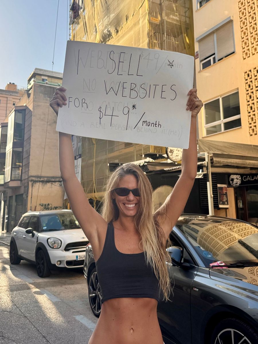 Amelia Babidge holding a handwritten sign: I sell websites for $49 a month